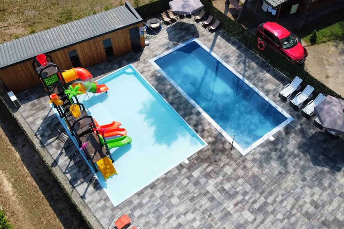 Strefa basenowa nocą – leżaki i lampiony